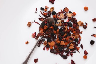 Beyaz arka planda kaşık ile kuru meyve çayı