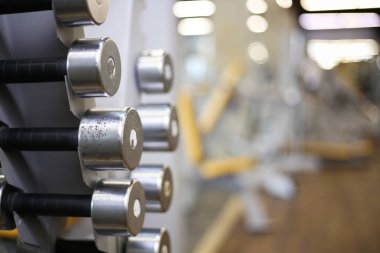 Bulanık spor arka planında metal halterli raflar