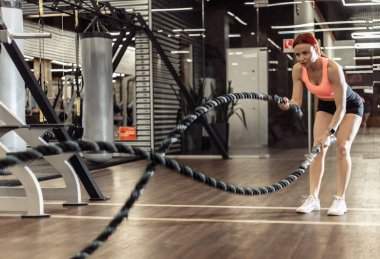 Yoğun idman, savaş halatlarıyla uyumlu bir kadın. Fonksiyonel eğitim