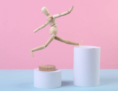 Geometrik şekilli mavi-pembe arka planda tahta bir kukla..