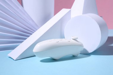 Pembe mavi arka planda modern joystick ve geometrik şekiller. Minimalizm. Sanat kavramı.