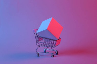 Mini alışveriş arabası ve kırmızı mavi ışıklı bir küp. Sanat kavramı, sürrealizm