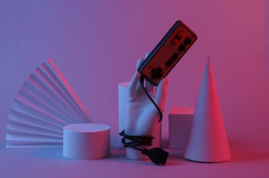El ele tutuşan retro oyun alanı, kırmızı-mavi neon ışıklı geometrik şekiller. Oyun konsepti. Sürrealizm. Sanat kavramı, geçmişe dönük fütürizm, minimalizm