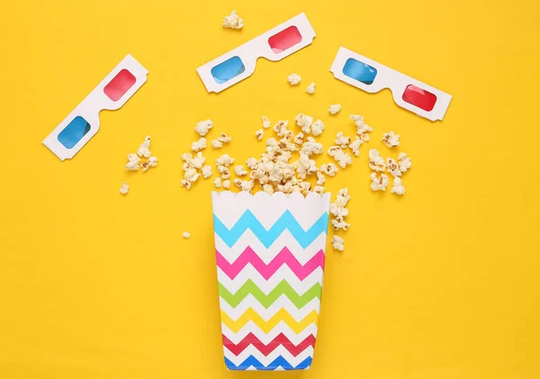 stock image Popcorn bucket and 3D glasses on yellow background. Top view. Flat lay