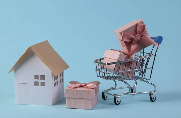 Carrinho Compras Com Caixas Presente Estatueta Casa Fundo Azul — Fotografia de Stock