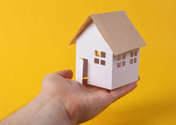 Hand Houdt Mini Papier Home Beeldje Gele Achtergrond Beschermingsconcept Veiligheid — Stockfoto