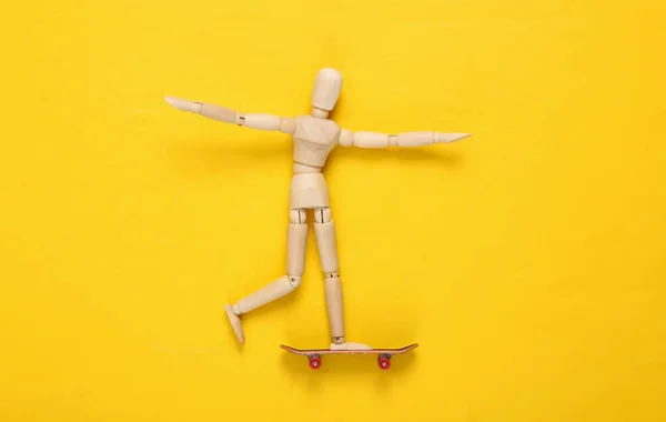 Die Puppe Sitzt Auf Einem Skateboard Gelber Hintergrund — Stockfoto