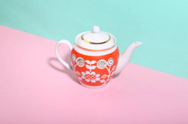 Mavi-pembe arka planda seramik retro çaydanlık. Minimalizm. Moda gölgesi. Yaratıcı yerleşim