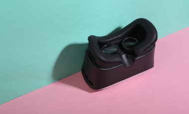 Mavi-pembe arka planda sanal gerçeklik kaskı. Minimalizm. Moda gölgesi. Yaratıcı yerleşim.