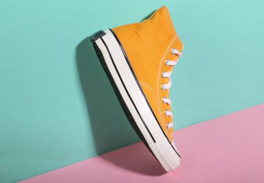 Mavi-pembe arka planda Retro Sneaker. Minimalizm. Moda gölgesi. Moda hala hayattadır. Yaratıcı yerleşim.