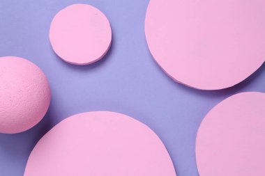 Pembe dairelerin yaratıcı arkaplanı ve mor zemin üzerinde bir top. Soyut arkaplan. Düz yatıyordu