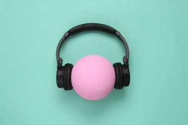 Mavi arka planda topu olan kulaklıklar. Asgari yaratıcı kompozisyon