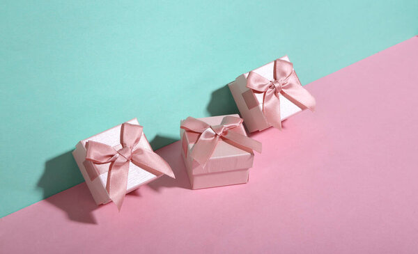 Gift boxes on blue-pink background. Minimalism. Trendy shadow. Creative layout.