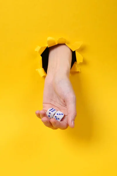 Kvinnlig Hand Håller Tärningar Genom Slitna Hål Gult Papper Spelberoende — Stockfoto