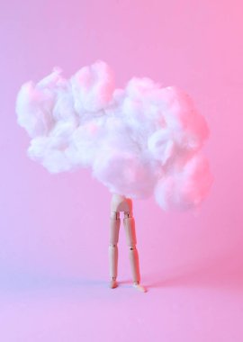 Uçan kabarık bulutta tahta kukla. Mavi pembe neon ışık. Yaratıcı bir fikir. Sanat kavramı. Minimalizm. Sürrealizm