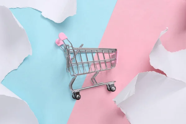 Mini Shopping Trolley Blue Pink Background Torn Paper Concept Art — Stockfoto