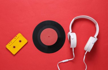 Stereo kulaklıklar, ses kaseti, kırmızı arka planda plak. Geçmişe dönük 80 'ler, hayat. Üst görünüm