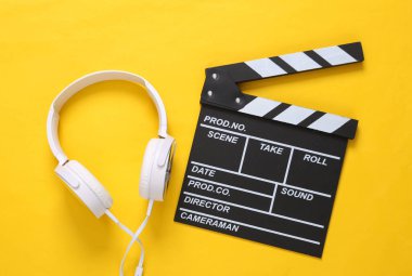 Sarı arka planda el bilgisayarı ve kulaklıklar. Üst görünüm