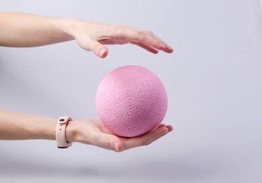 Gri arka planda pembe bir balon tutuyor. Minimalizm yeni fikir kavramı