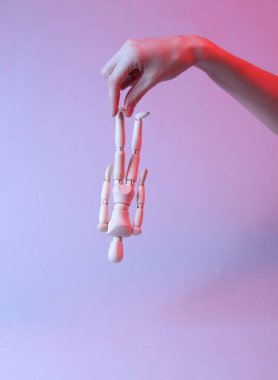 Kırmızı-mavi neon ışıkta bir kuklayı baş aşağı tutuyor..