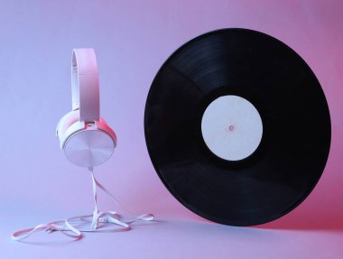 Beyaz kulaklıklar ve kırmızı mavi ışıklı vinil plaklar.