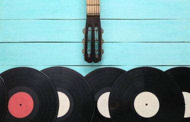 Akustik gitar yaka, mavi ahşap arka planda vinil plak. Müzik konsepti. Minimalizm. Üst Manzara. Düz yatıyordu