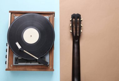 Akustik gitar ve mavi kahverengi arka planda retro vinil plak çalar. Müzik konsepti. Üst Manzara. Düz yatıyordu
