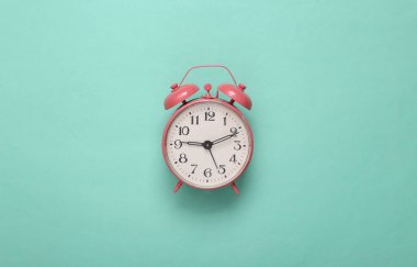 Nane yeşili arka planda pembe alarm saati. Minimalizm. Üst Manzara. Düz yatıyordu