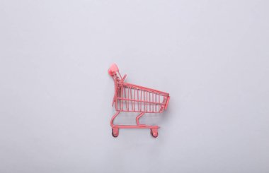 Gri arka planda mini pembe market tramvayı. Üst Manzara. Minimalizm. Düz yatıyordu