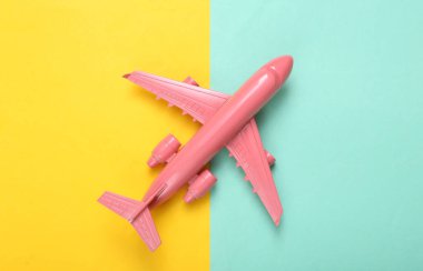 Minimum seyahat planı. Mavi sarı arka planda pembe bir uçak. Düz yatıyordu. Üst görünüm