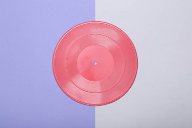 Yaratıcı müzik düzeni. Mor gri arka planda pembe vinil plak. Minimalizm. Düz yatıyordu. Üst görünüm.