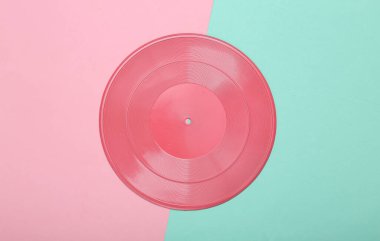 Yaratıcı müzik düzeni. Pembe mavi arka planda pembe vinil plak. Minimalizm. Düz yatıyordu. Üst görünüm.