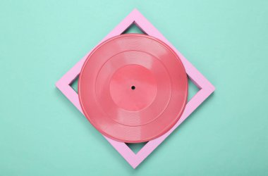 Yaratıcı asgari düzen. Nane mavisi arka planda çerçeveli pembe vinil plak. Minimalizm. Sanat kavramı. Düz yatıyordu. Üst görünüm.