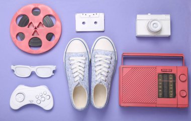 Retro hipster pembe beyaz özellikler ve mor arka planda spor ayakkabılar. Minimalizm, yaratıcı düzen. Düz yatıyordu. Sanat kavramı. Üst görünüm 