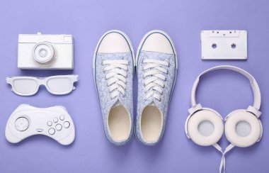 Retro hipster beyaz özellikleri ve mor arka planda spor ayakkabıları. Minimalizm, yaratıcı düzen. Düz yatıyordu. Sanat kavramı. Üst görünüm 