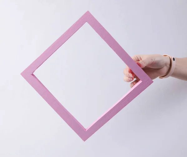 女性の手は灰色の背景にピンクの枠を持っています 新鮮なアイデア ミニマリズム — ストック写真