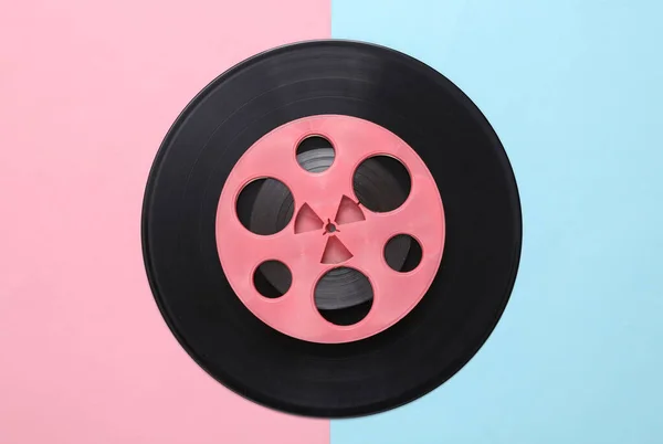 ブルーピンクの背景にピンクのレトロオーディオリールとビニールレコード ミニマリズム音楽の概念 トップ表示 — ストック写真