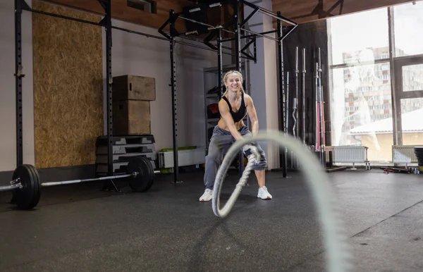 Atletik Güçlü Kadın Modern Spor Salonunda Savaş Halatıyla Egzersiz Yapıyor — Stok fotoğraf