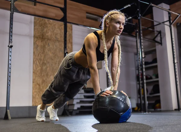 Modern Spor Salonunda Tıp Topuyla Şınav Çeken Atletik Bir Kadın — Stok fotoğraf