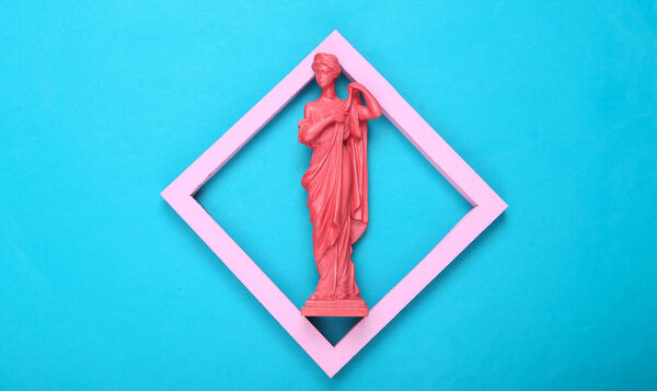 Creative layout. Pink Antique greek goddess statue in frame on blue background. Minimalism. Flat lay. Top view