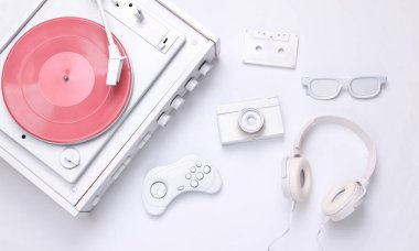Retro yaratıcı tasarım. Beyaz plak çalar, kamera, oyun platformu, ses kaseti, gözlük, kulaklık beyaz arka planda. Üst Manzara. Düz yatıyordu