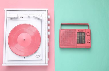 Beyaz Turntable Vinil Plak çalar ve pembe radyo alıcısı pembe mavi pastel arka planda. Müzik teknolojisi. Minimalizm. Düz yatıyordu. Üst görünüm
