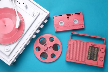 Retro yaratıcı tasarım. Beyaz plak çalar, pembe ses kaydı, video kaset, mavi arka planda radyo alıcısı. Müzik ve video. Üst Manzara. Düz yatıyordu