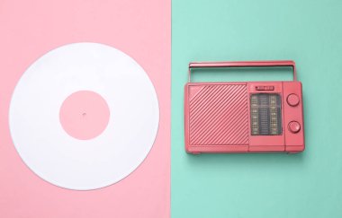 Yaratıcı müzik düzeni. Pembe arka planda beyaz plak ve pembe radyo alıcısı. Minimalizm. Üst Manzara. Düz yatıyordu