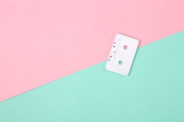 Minimalizmin yaratıcı düzeni. Pembe arka planda beyaz ses kaseti. Minimalizm. Üst Manzara. Düz yatıyordu