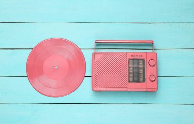 Yaratıcı müzik düzeni. Pembe plak ve mavi ahşap arka planda radyo alıcısı. Minimalizm. Üst Manzara. Düz yatıyordu