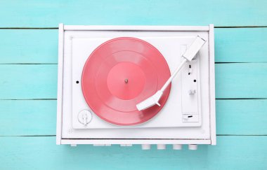 Turntable plakçalar mavi ahşap arka planda. DJ 'in müziği karıştırıp çalması için ses teknolojisi. Beyaz plak plağı. Minimalizm. Düz yatıyordu. Üst görünüm.