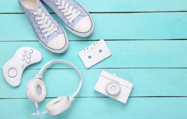 Sanat kavramı. Spor ayakkabılarının yaratıcı retro düzeni ve 80 'lerin diğer eski özellikleri mavi ahşap arka planda. Üst Manzara. Düz yatıyordu