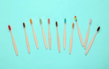 Pembe mavi arka planda bir sürü çevre dostu bambu diş fırçası. Üst görünüm.