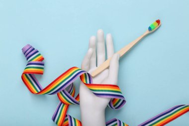 Mavi arka planda diş fırçası ve gökkuşağı bandı. Lgbt kavramı